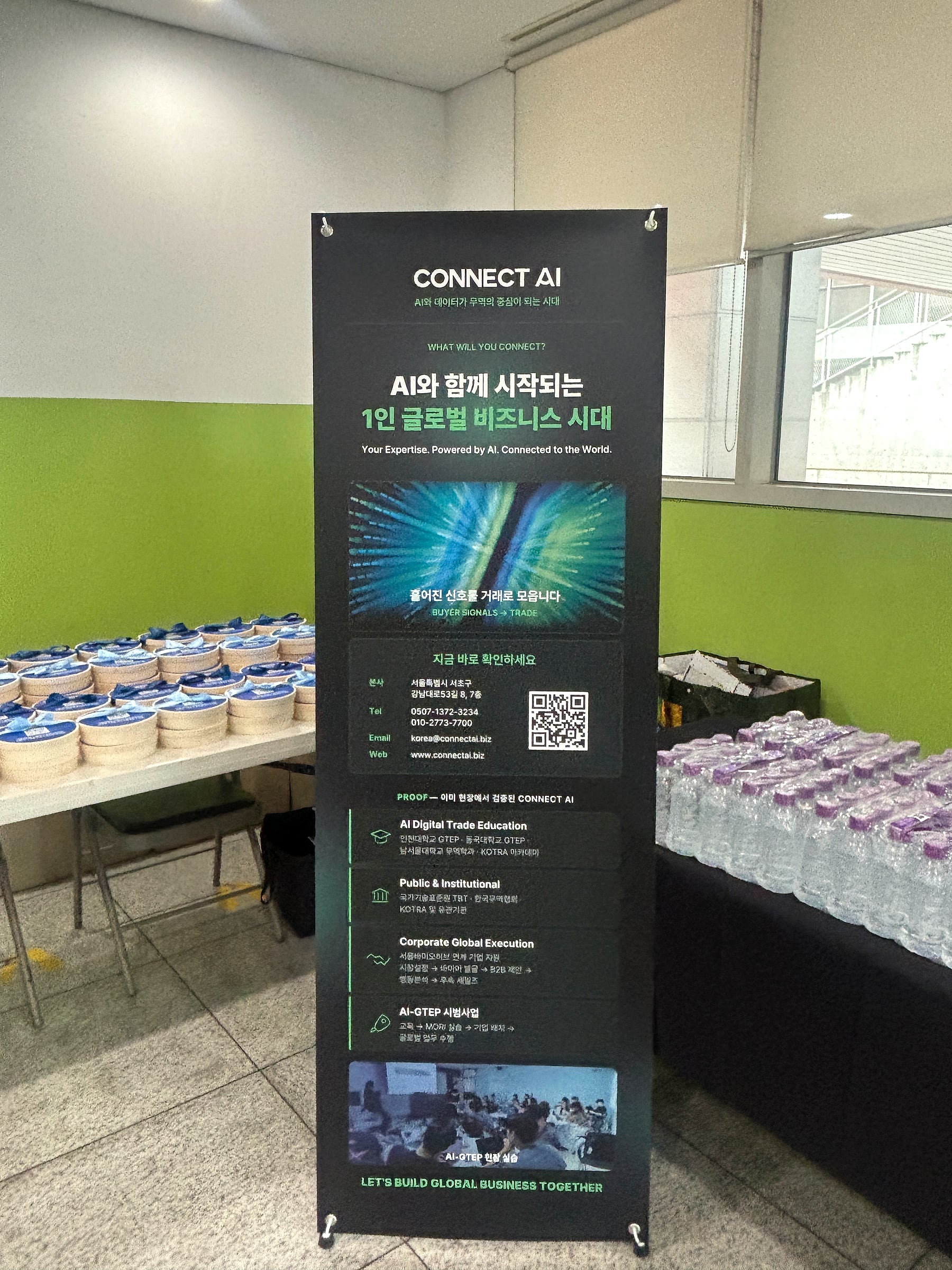 会場のCONNECT AIバナーと食事を並べたテーブル