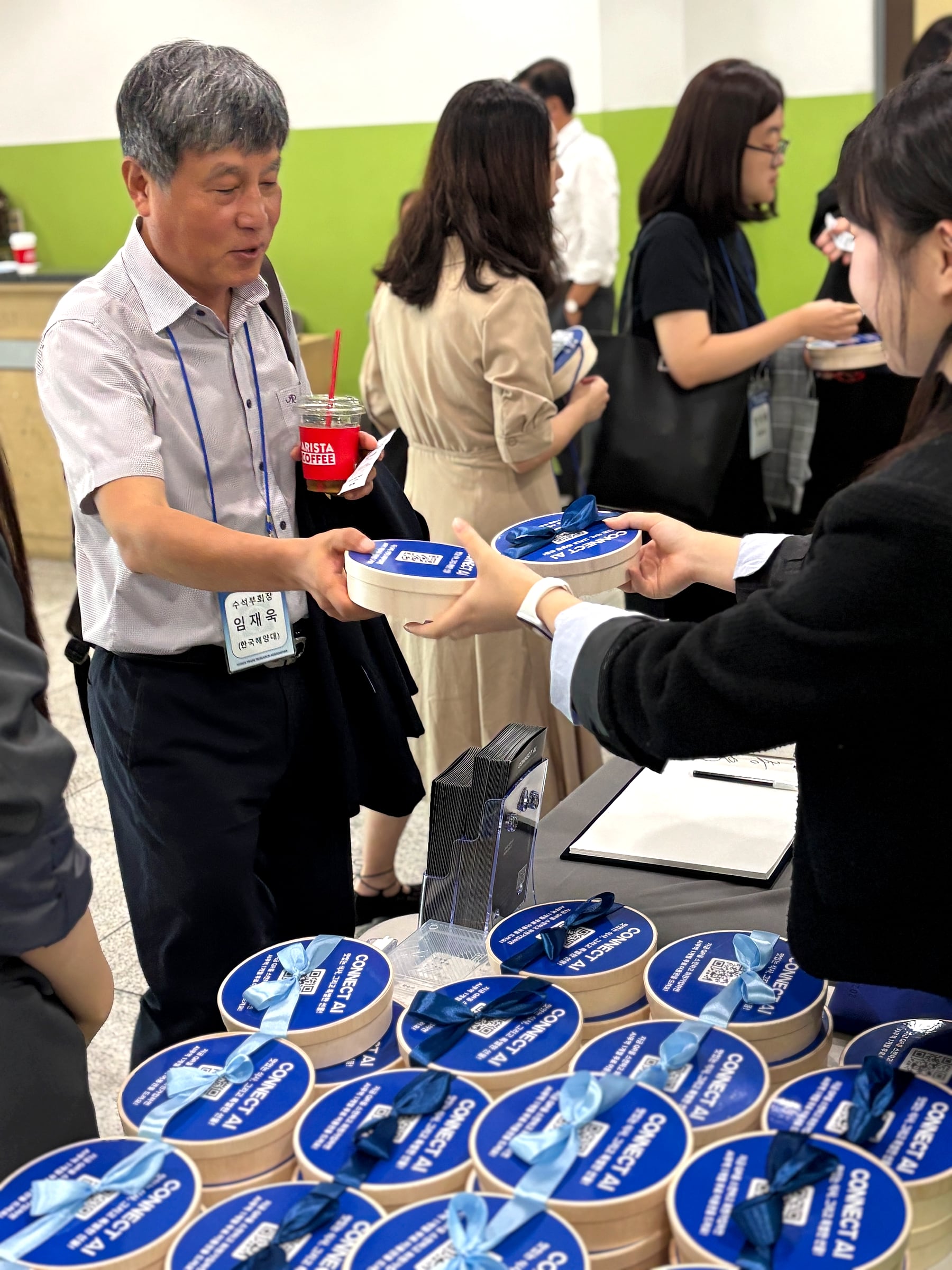 受付テーブルで食事パッケージを手渡す様子